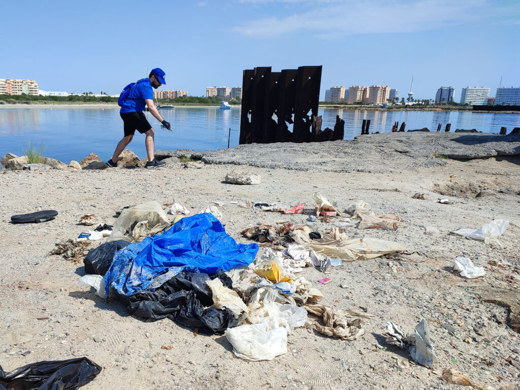 Un voluntario recoge residuos en la Caleta del Estacio